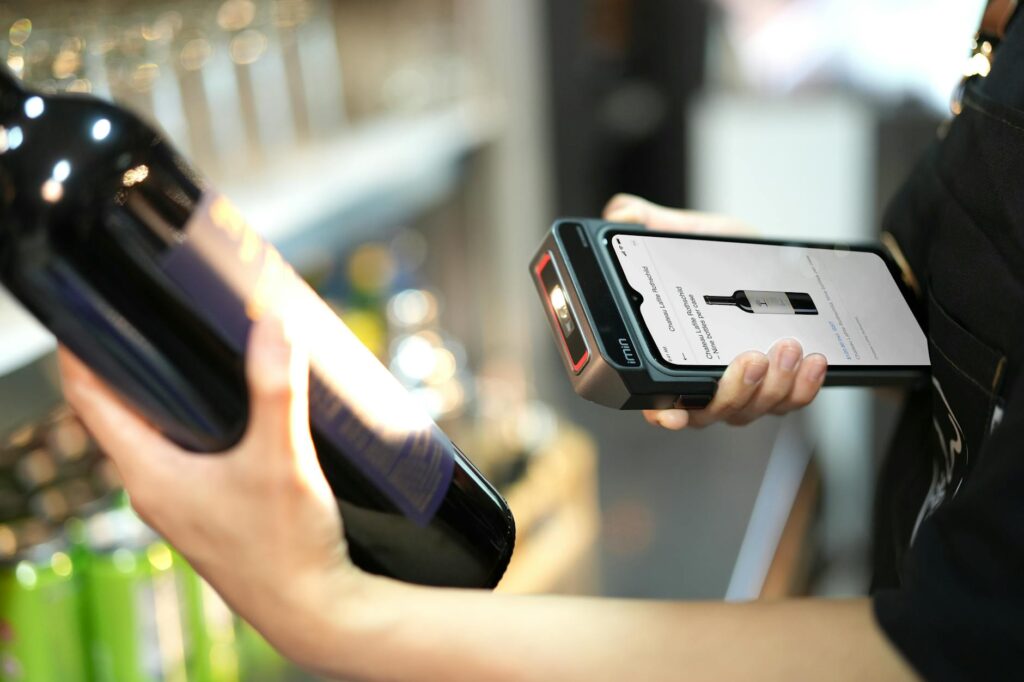 person using scanner on bottle of wine